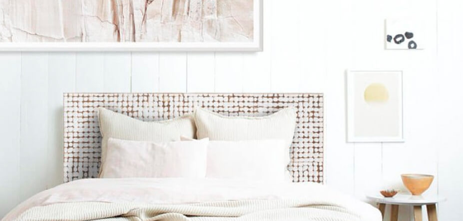 Light and airy bedroom with wooden white washed headboard 